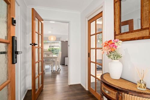 卡尔斯The Green Garden Gate - Phillip Island的走廊里桌子上有一瓶花
