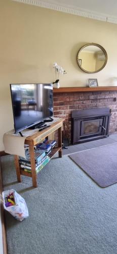 a living room with a television and a fireplace at Belle Cottage in Scottsdale