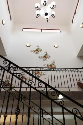 a staircase with butterflies painted on the ceiling at Brisas del Aeropuerto in Heredia
