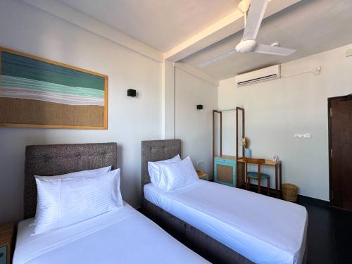 two beds sitting next to each other in a room at Moi Induruwa by DBI in Bentota