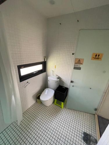 a small bathroom with a toilet and a window at 幸福客棧 in Ho-mei