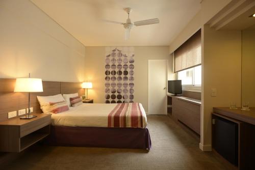 Habitación de hotel con cama y TV en Bisonte Palace Hotel en Buenos Aires
