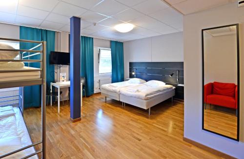 a bedroom with a bed and a desk and a mirror at Spoton Hostel & Sportsbar in Gothenburg