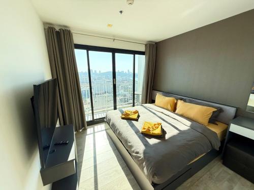 una camera da letto con un letto con una grande finestra di The Base - Spacious 70sqm, 2 Bedroom, 2 bathroom, Penthouse Condo - Pattaya City Centre - 592 a Centro di Pattaya