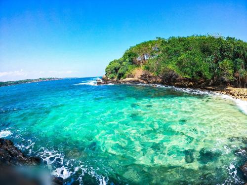 an island in the ocean with turquoise water at Mount Side Hiriketiya in Hiriketiya