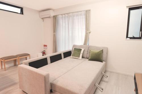 a living room with a couch with two pillows on it at Direct to Namba, Umeda ,Airport! New house!3mins to subway! in Osaka
