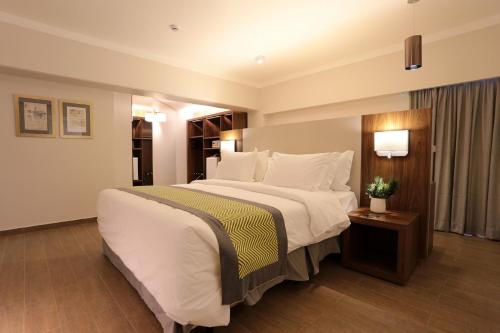 a large white bed in a hotel room at Oasis Plaza Hotel in Ribeirão Preto