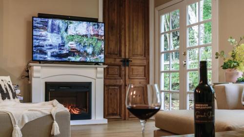 a living room with a wine glass and a fireplace at Frazer Place - Thoughtful Country Lodge in Daylesford