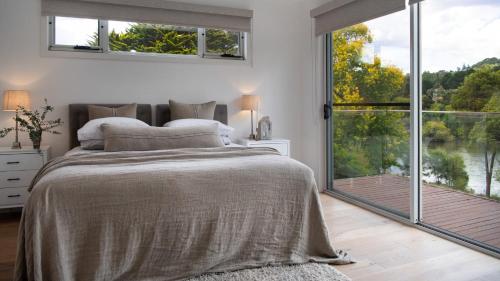 a bedroom with a large bed and a large window at Province Lake House in Daylesford