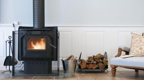 a wood stove in a living room with a couch at Grenville Belle Daylesford in Daylesford