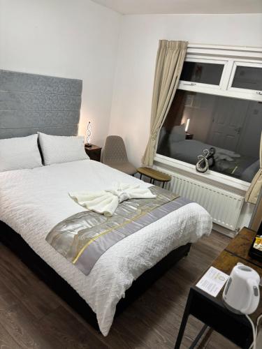 a bedroom with a large bed and a window at Comfortable Ensuite Rooms and Ample Street Parking in Doncaster