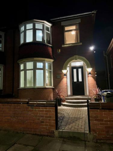 a brick house with a front door at night at Comfortable Ensuite Rooms and Ample Street Parking in Doncaster