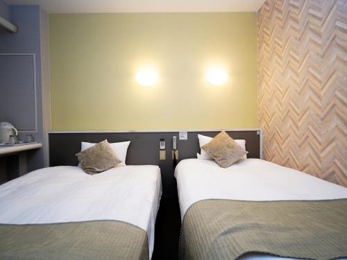 two beds sitting next to each other in a room at Hotel Areaone Okayama - Vacation STAY 32495v in Okayama