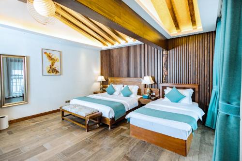 a hotel room with two beds and a table at 丽江束河元年别院 Yuannian Lijiang in Lijiang