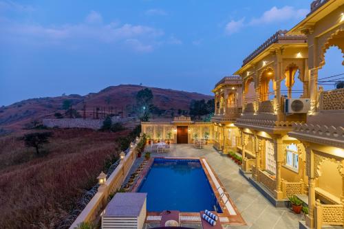 an aerial view of a mansion with a swimming pool at ELIVAAS Amber Royale 3 BHK with Pvt Pool & Terrace in Udaipur