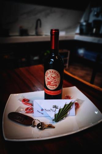 a bottle of wine sitting on top of a plate at Yarumo Lodge, Río Celeste Black Chalets in Bijagua