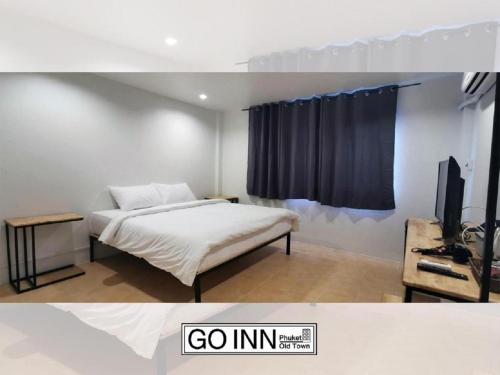 a bedroom with a bed and a tv in a room at GO INN Phuket Old Town ภูเก็ตโอลทาวน์ ย่านเมืองเก่า in Phuket