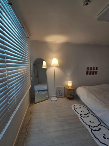 una camera con letto, lampada e specchio di Palace outing a Suwon