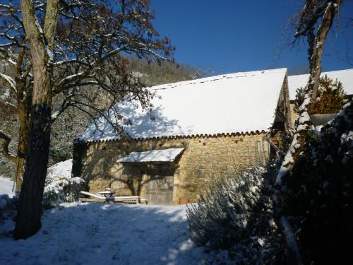 a building with snow on the roof of it at Le Mas de Laval in Saint-Cirq-Lapopie