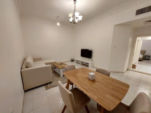 a living room with a dining room table and a television at HARF22G02-02 stylish 2BR in AD in Abu Dhabi