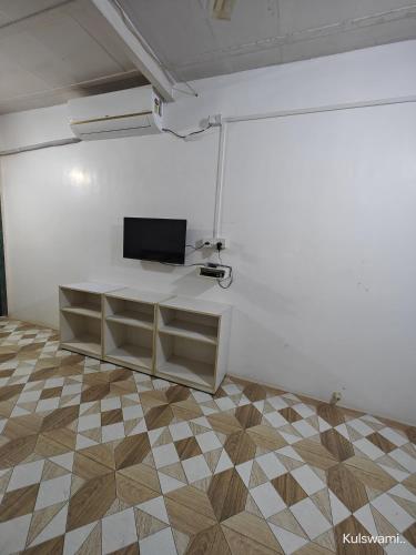 a living room with a tv on a white wall at Kulswami Cottage Alibag in Alibaug