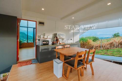 a kitchen and dining room with a wooden table and chairs at Sky View Mon Jam in Chiang Mai
