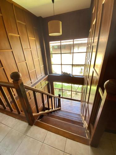 a hallway with a wooden staircase with a window at Baan Laem Noi Villa's in Mae Nam