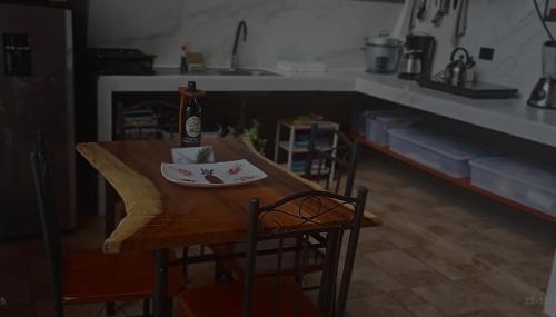 a dining room table with a bottle of wine on it at Yarumo Lodge, Río Celeste Black Chalets in Bijagua