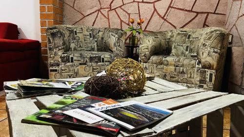 a table with books on it next to a couch at Casa Dahlia Querétaro in Querétaro