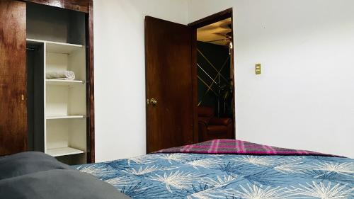 a bedroom with a bed and an open closet at Casa Dahlia Querétaro in Querétaro