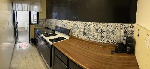 a kitchen with a stove and a counter top at Casa Dahlia Querétaro in Querétaro