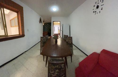 a living room with a table and a red couch at Casa Dahlia Querétaro in Querétaro
