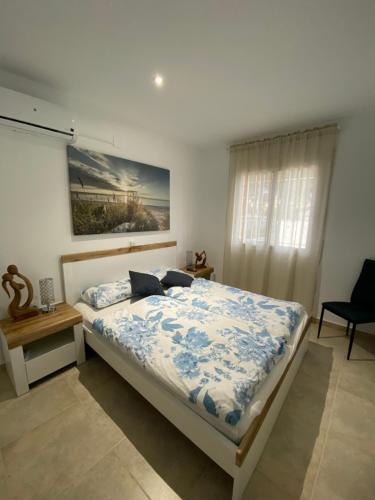 a bedroom with a bed with a blue and white comforter at El Barco in L'Ametlla de Mar