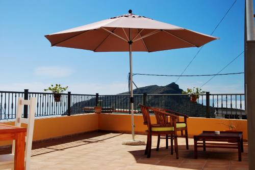 a patio with an umbrella and a table and chairs at Casa Regina Tenerife in Tamaimo