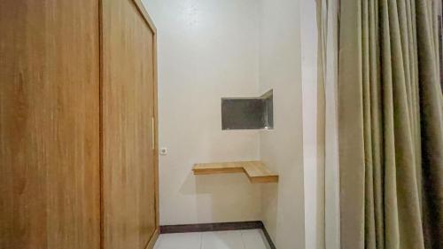 a room with a television and a door with a curtain at AIVY Living by AIVY ID Official in Bandung