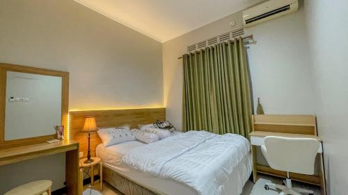 a bedroom with a bed with a mirror and a chair at AIVY Living by AIVY ID Official in Bandung