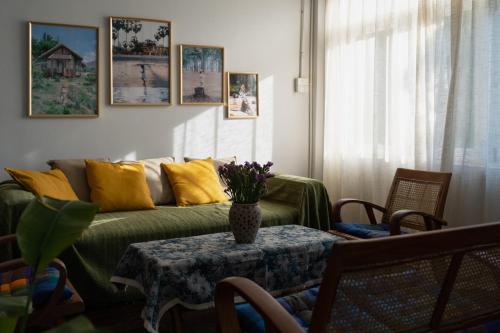 a living room with a couch and a table with a vase on it at 清迈古城柚子别墅塔佩门里 in Chiang Mai