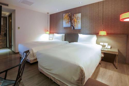 a hotel room with two beds and a desk at CHECK inn SELECT Hualien LinSen in Hualien City
