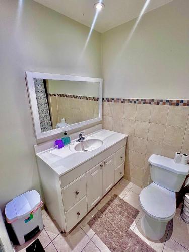a bathroom with a sink and a toilet and a mirror at Private Room Near Airport D1 in Brampton