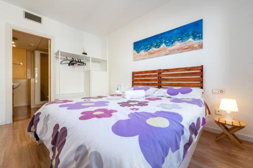 a bedroom with a large bed with purple flowers on it at Una joya en Tarragona in Tarragona