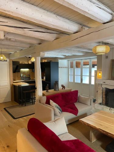 un salon avec un canapé rouge et une table dans l'établissement Le Chalet de Carole, à Cadéac