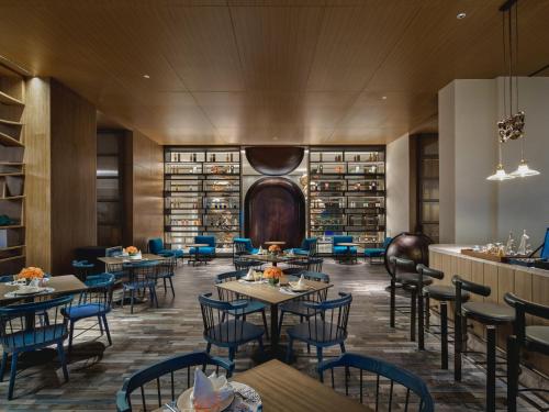 a restaurant with tables and chairs in a library at Hotel Indigo Yantai Golden Coast by IHG in Yantai