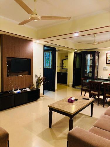 a living room with a couch and a table at LUXUS INN JA - Sapphire Suite in Trivandrum