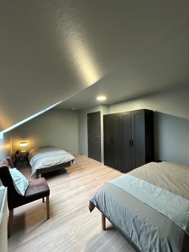a bedroom with two beds and a chair in a room at The175 work or holiday home in Comines