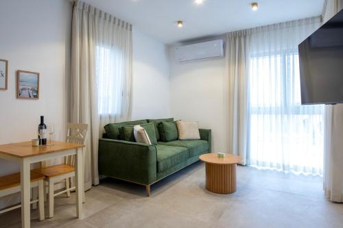 a living room with a green couch and a table at סקנד פלור סוויטה מודרנית מפנקת ברמת הגולן in Qasrîne