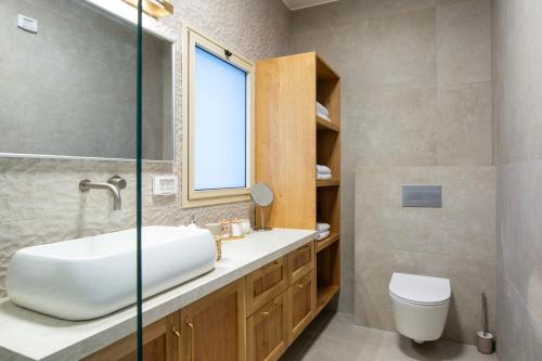a bathroom with a sink and a toilet and a window at סקנד פלור סוויטה מודרנית מפנקת ברמת הגולן in Qasrîne