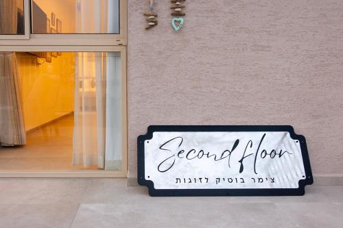 a sign on the side of a store window at סקנד פלור סוויטה מודרנית מפנקת ברמת הגולן in Qasrîne