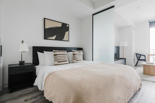 a white bedroom with a large bed with pillows at Blueground Downtown pool AC nr Capitol ATX-291 in Austin