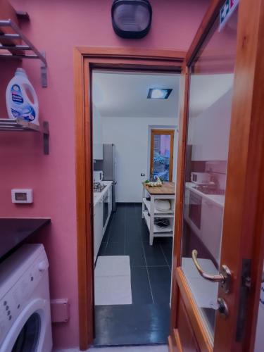 a bathroom with a pink wall and a washing machine at Appartamento Principe in Monterosso al Mare