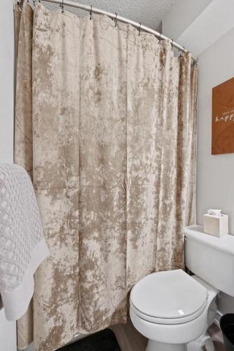 a bathroom with a toilet and a shower curtain at Stunning Area, King Suite, Balcony, Free Parking, 2 mins to UT in Austin